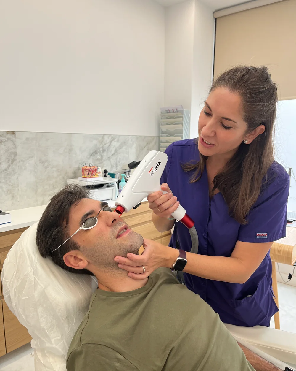 Patricia García Martín realizando un tratamiento facial con un dispositivo láser en Clínica GM